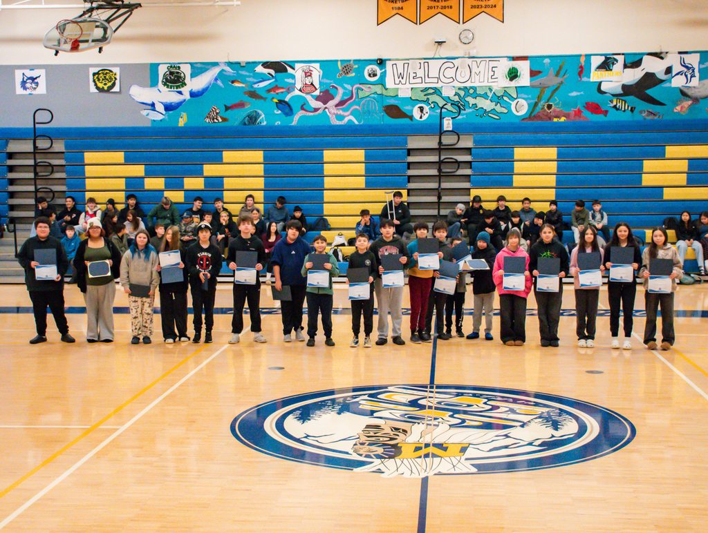 students in gym holding certificates