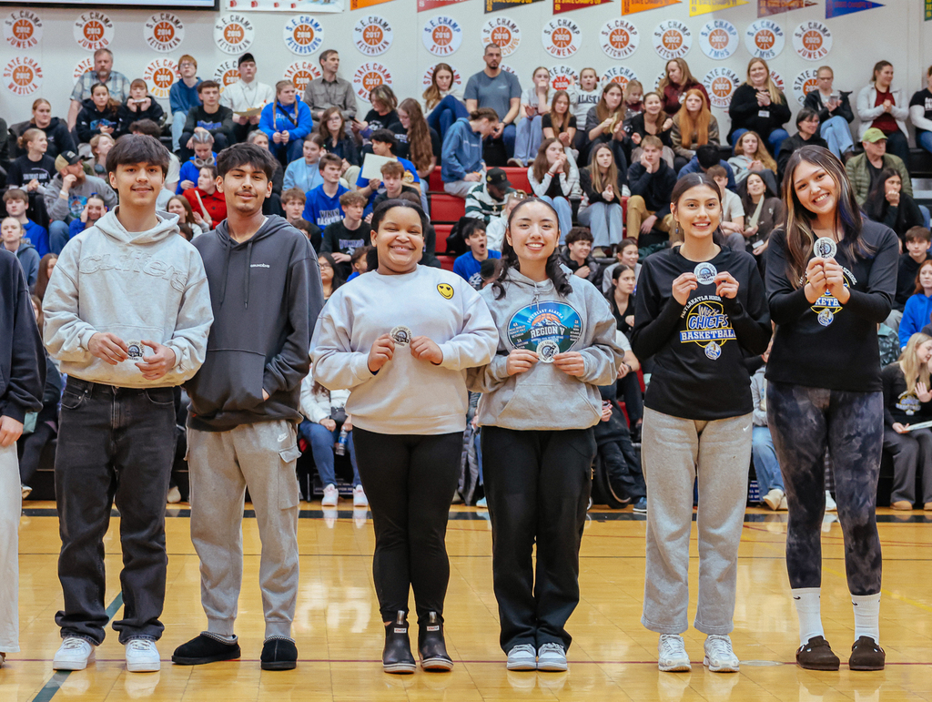 students on basketball court posing holding stickers