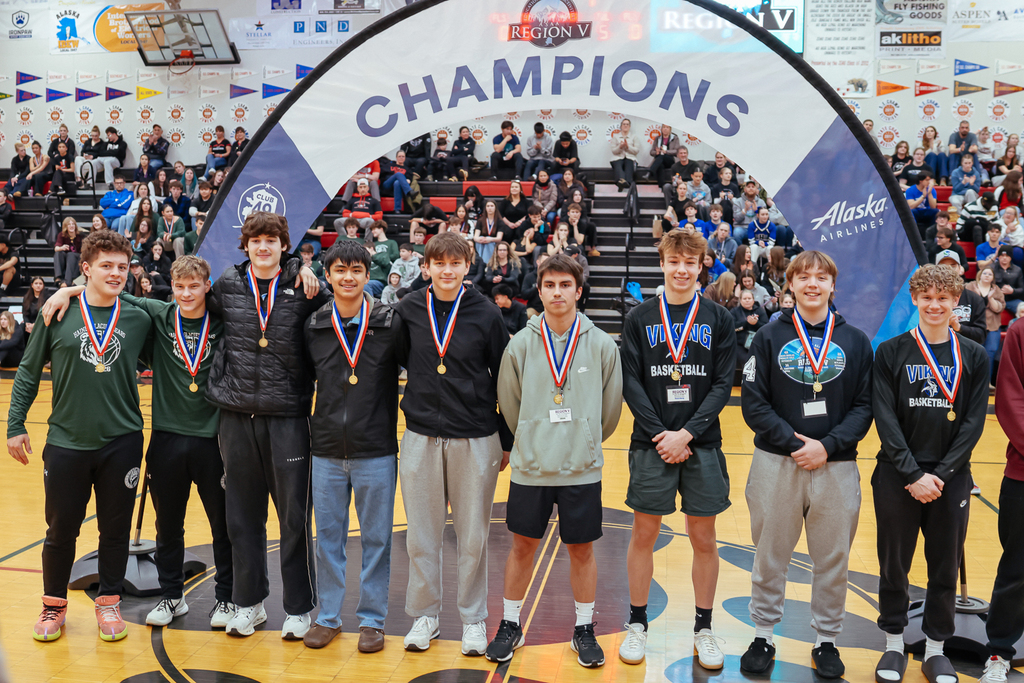 students on basketball court posing wearing medals
