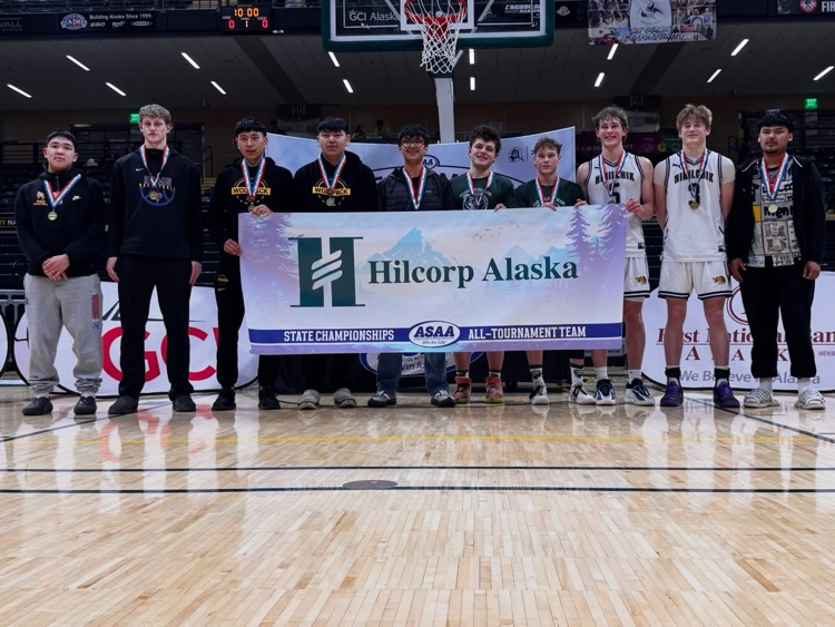students in a gym holding a sign 
