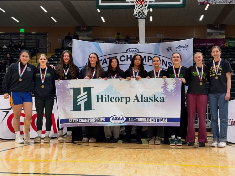 students in a gym holding a sign 