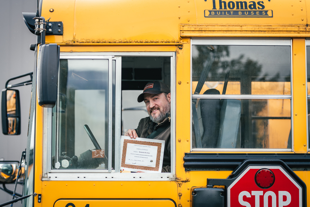 bus driver holding certificate in a bus