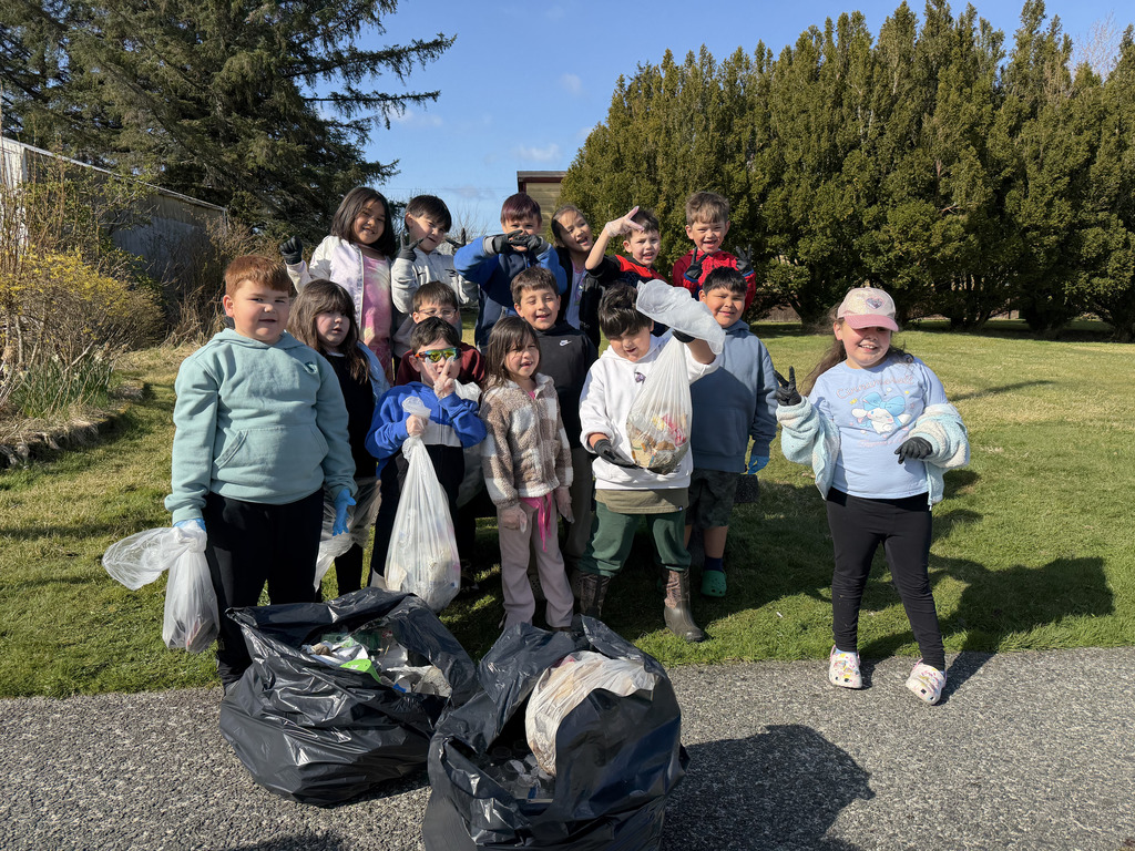 students outside holding garbage bags
