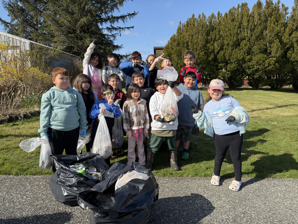 students outside holding garbage bags