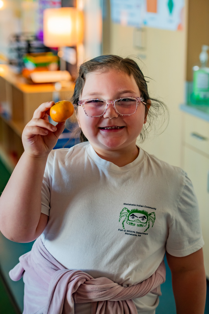 student eating a tangerine in a classroom