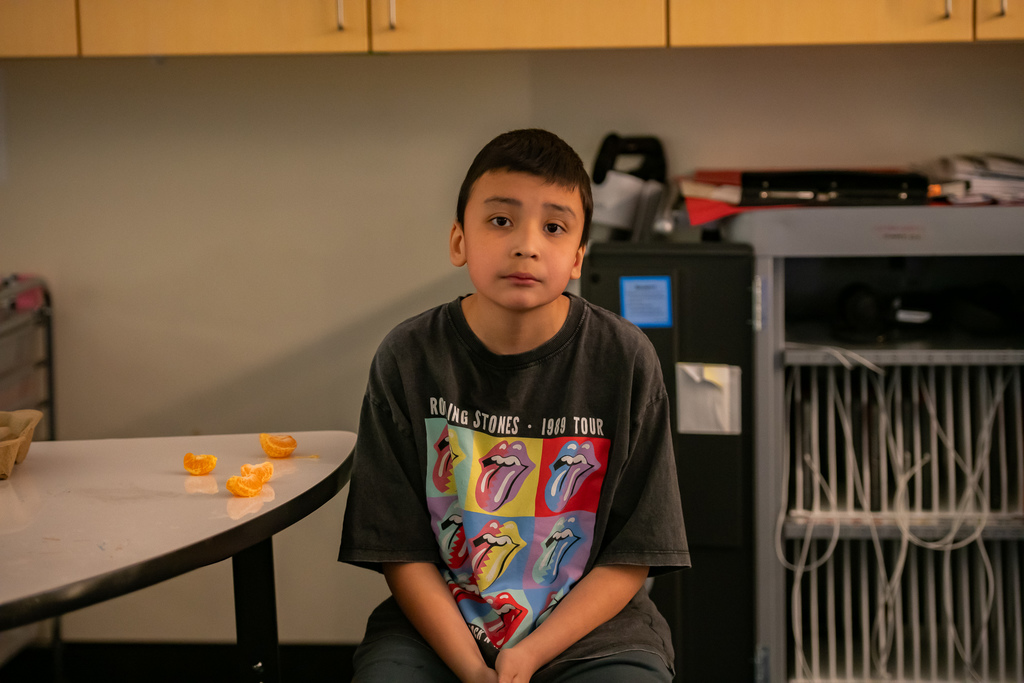 student eating a tangerine in a classroom