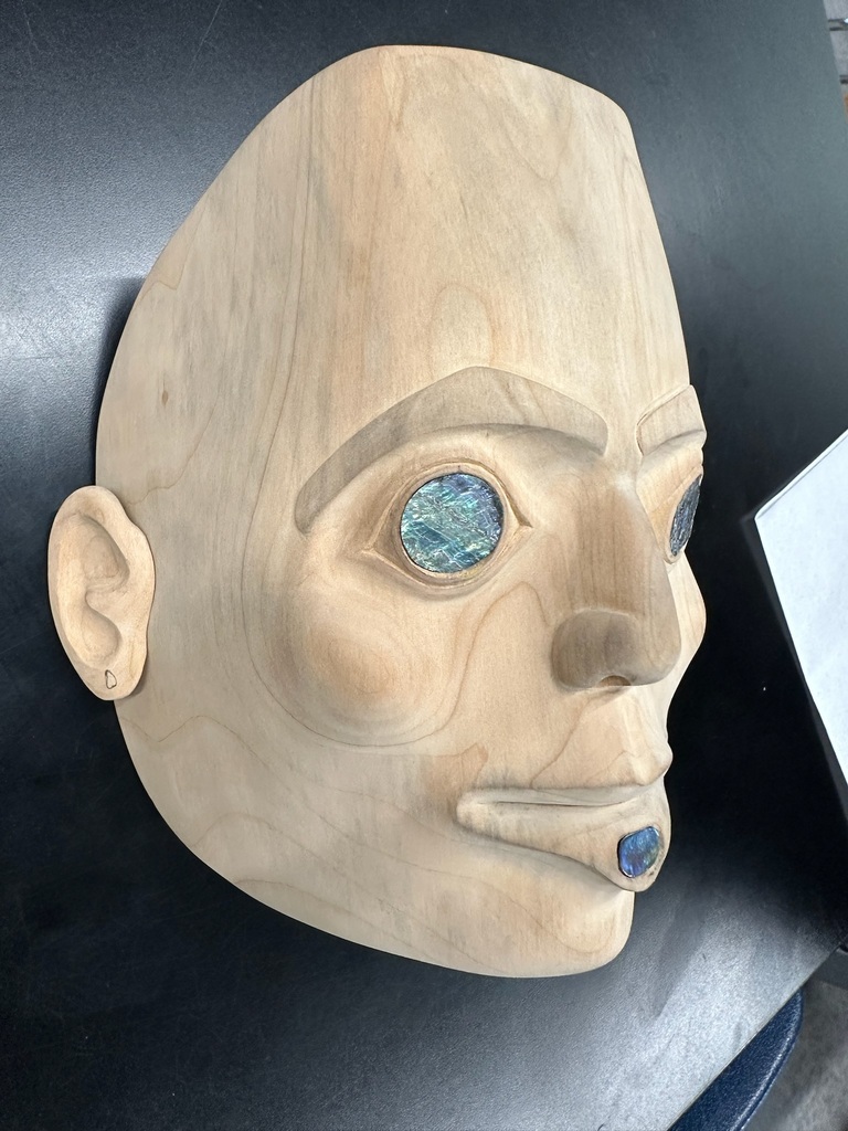 carved mask with abalone