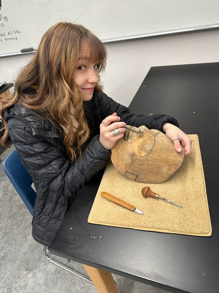 student carving a mask