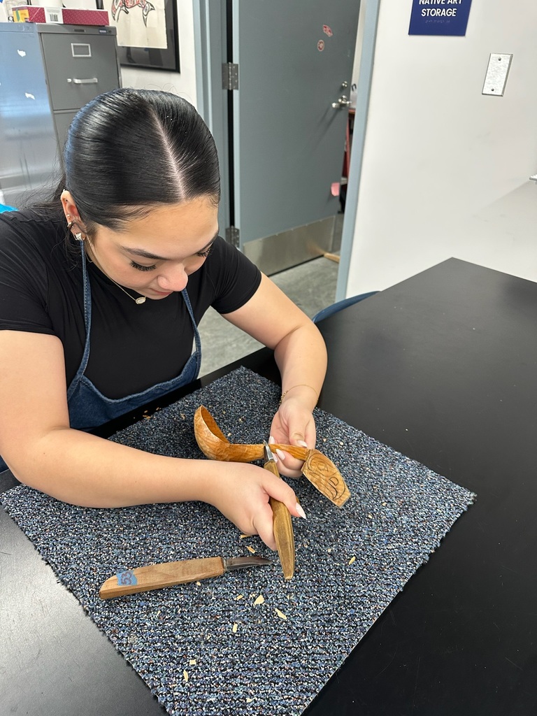 student carving a spoon