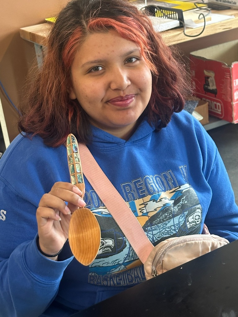 student holding a carved wooden spoon