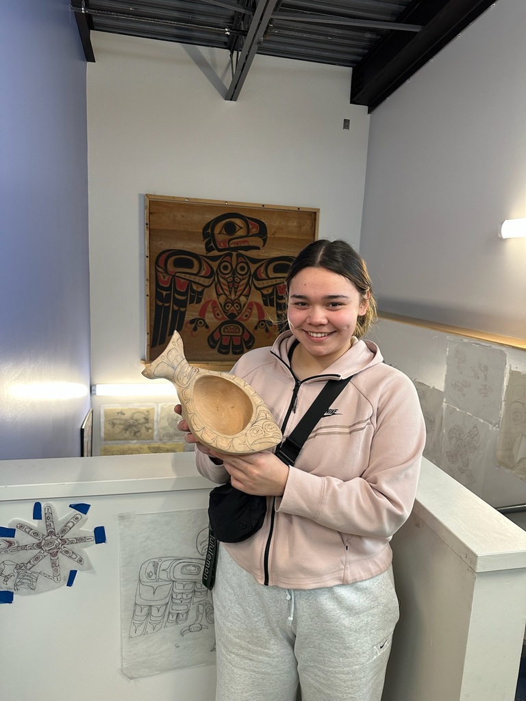 student holding up carved bowl