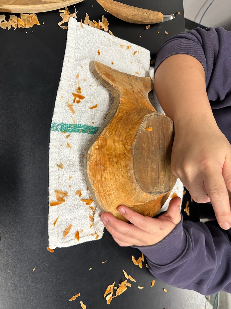 hands working on carving a bowl