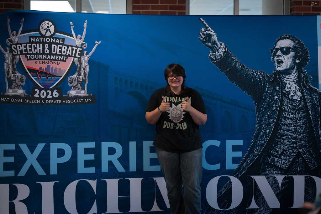 student posing in front of a sign that says "experience richmond" 