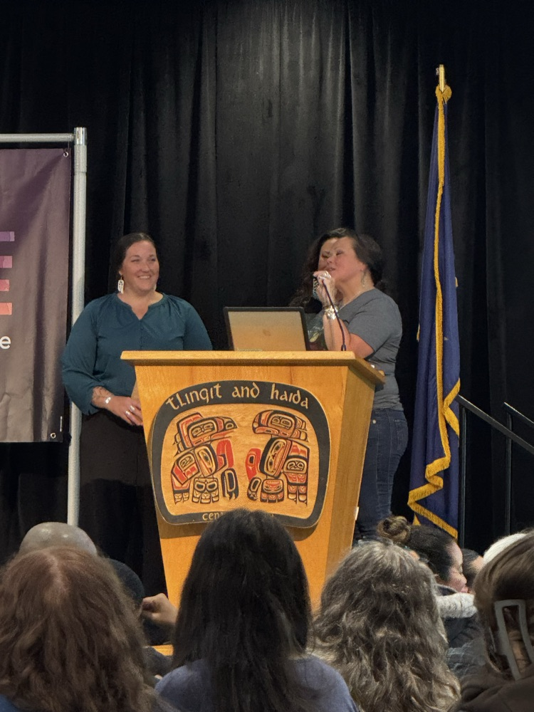 woman receiving award at podium