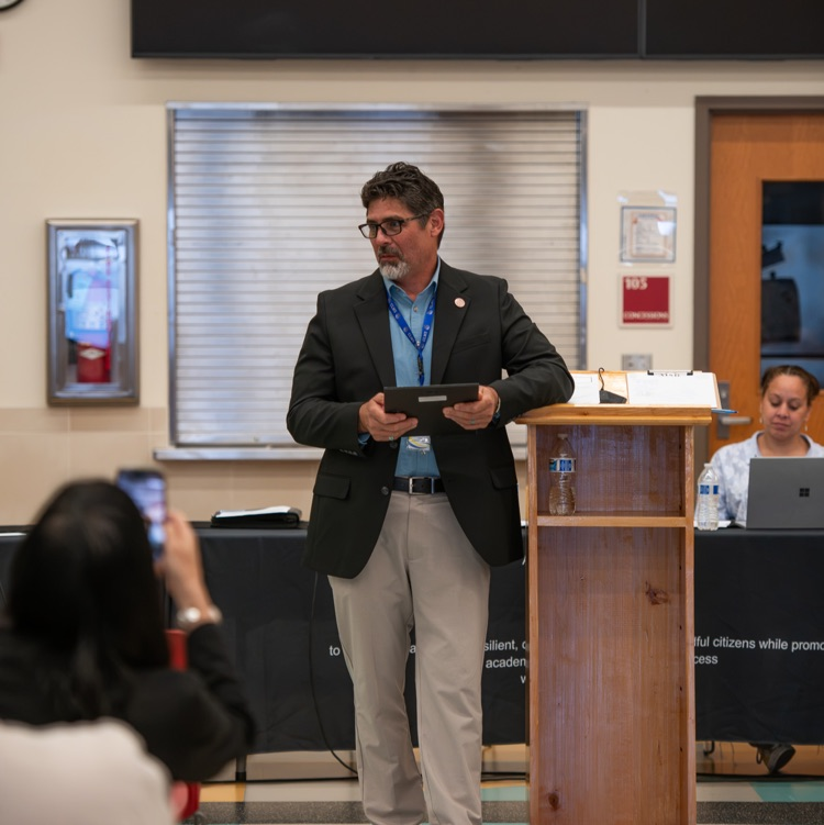 man holding award at a podium