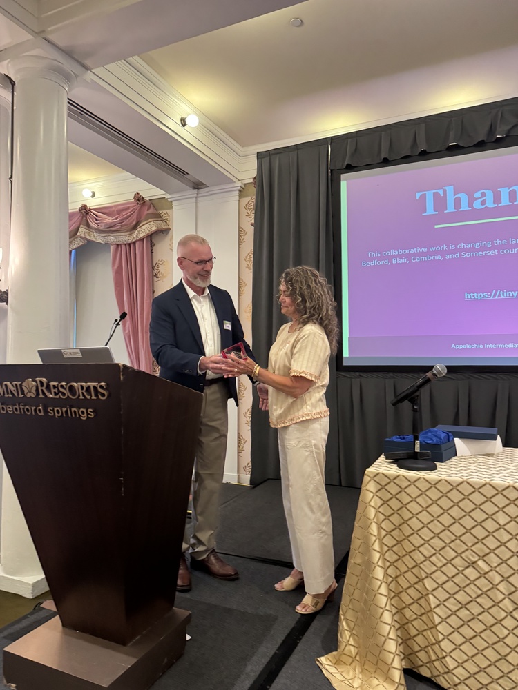 Person giving award to another person