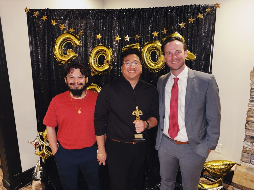 three people holding an award