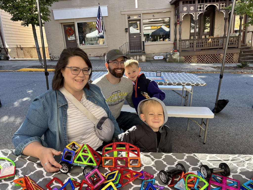 two adults with two kids at a fall festival