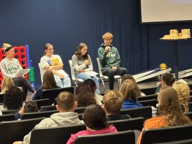 Four students on a panel at a conference