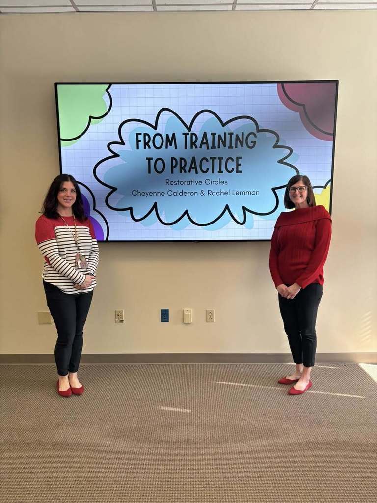 Two people standing in front of a presentation screen