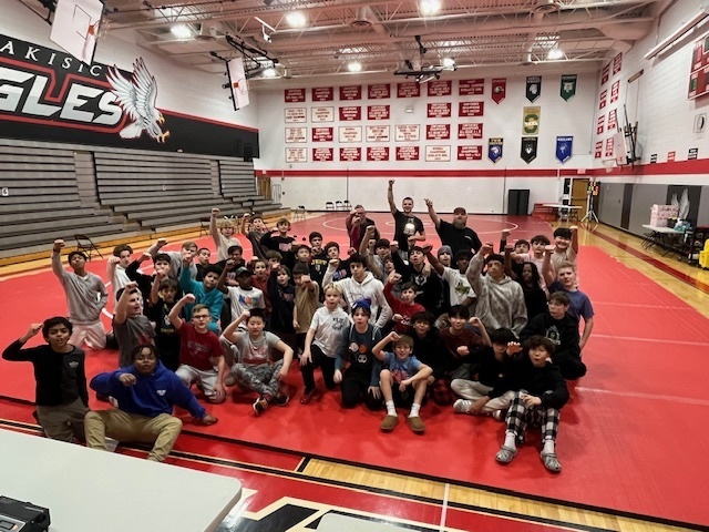 Wrestling students cheering on a mat.