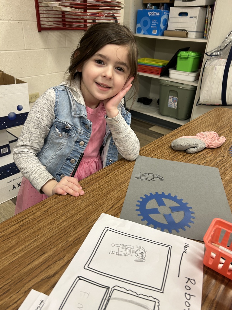 Student sitting with her final copy and stencil.