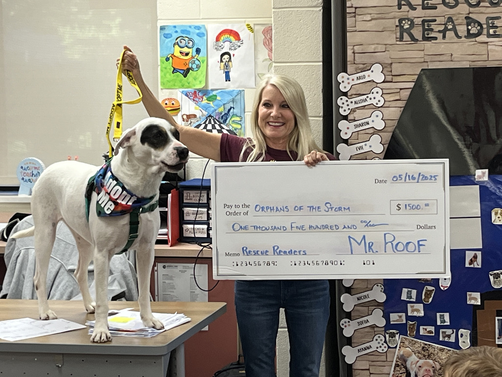 Teacher holding check and dog.
