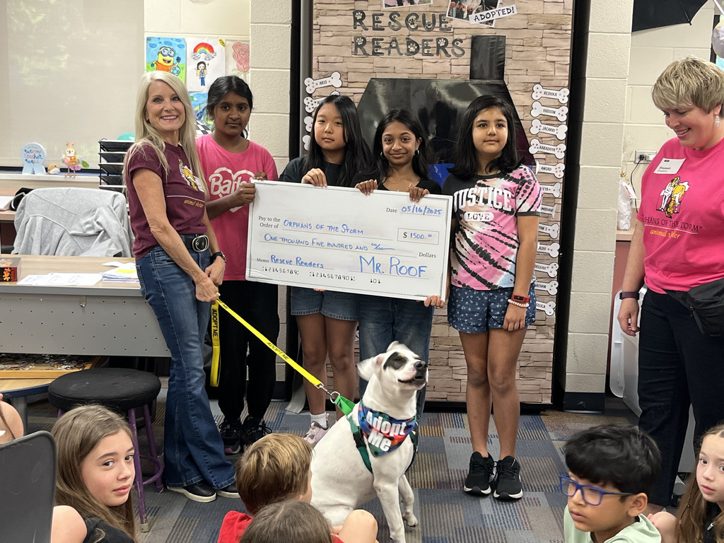 Students posing with dogs and check.