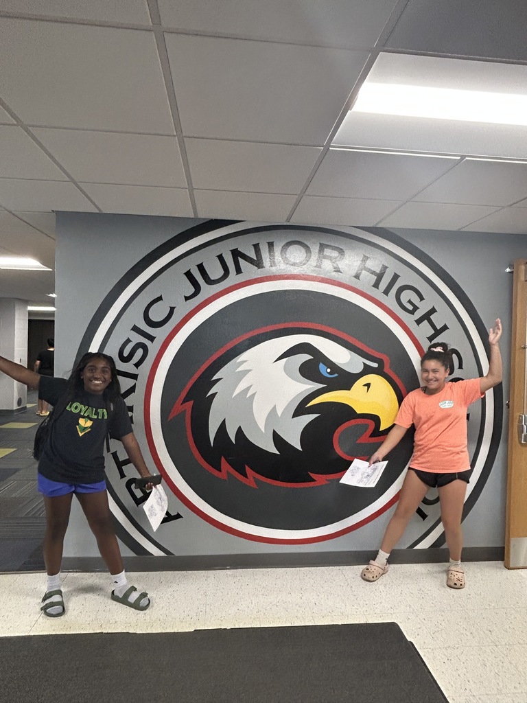Students posing by the logo.