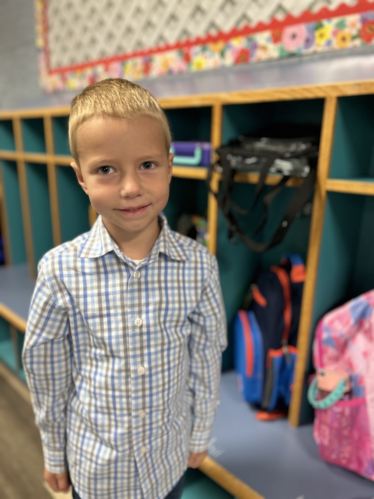 Student standing by his cubby.