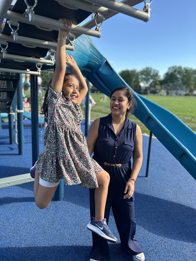 Girl on monkey bars with mom.