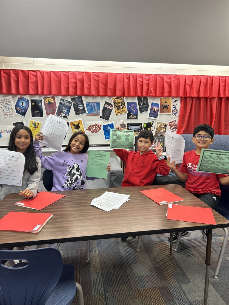 Students holding up their work. 