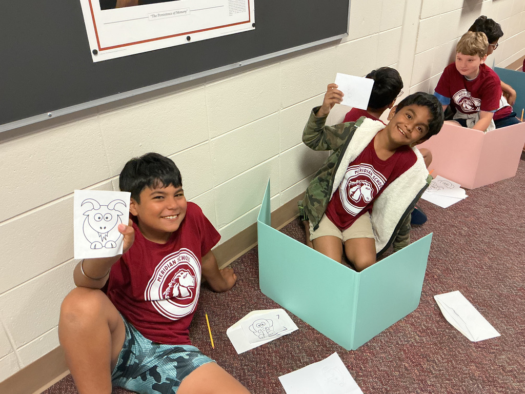Students holding up a coloring page.
