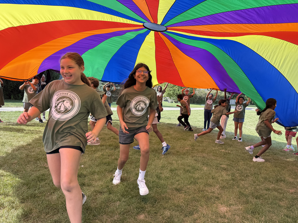 Students running under a parachute.