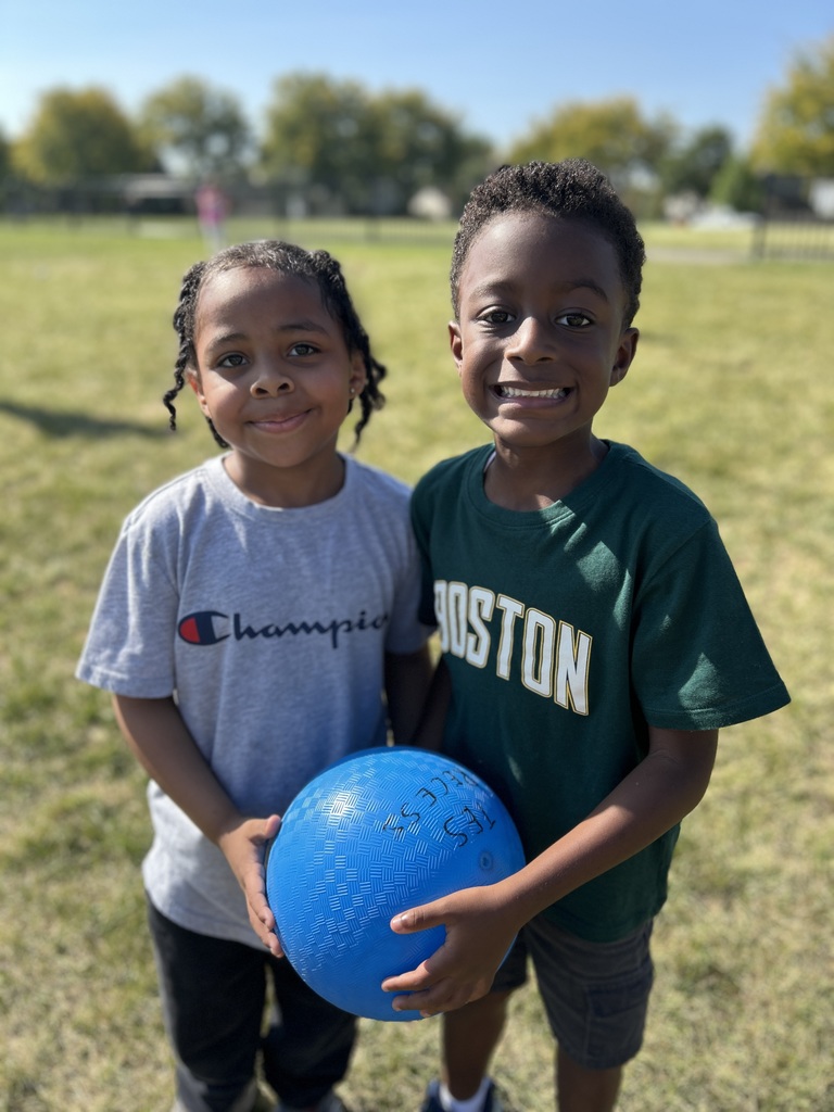 Two boys holding a blue ball.