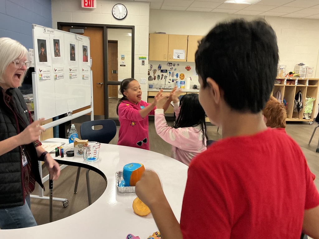 Kids watching an experiment with a pumpkin.