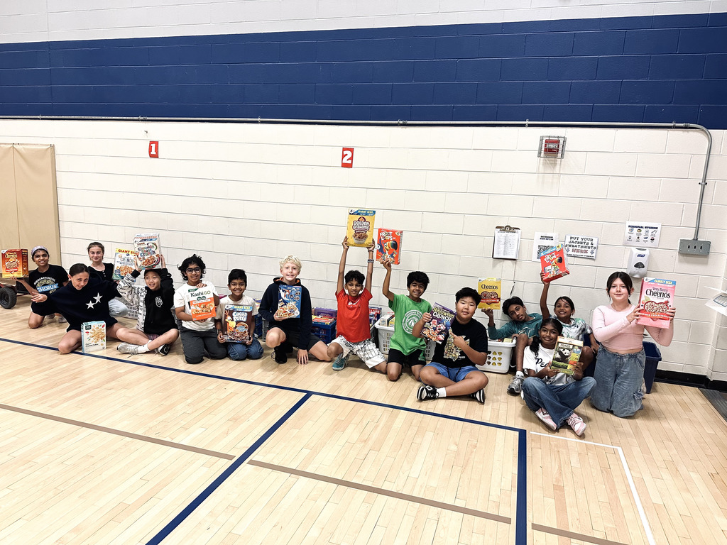 Students holding up their boxes in the gym.