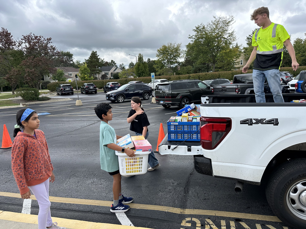 Students loading a truck with boxes.