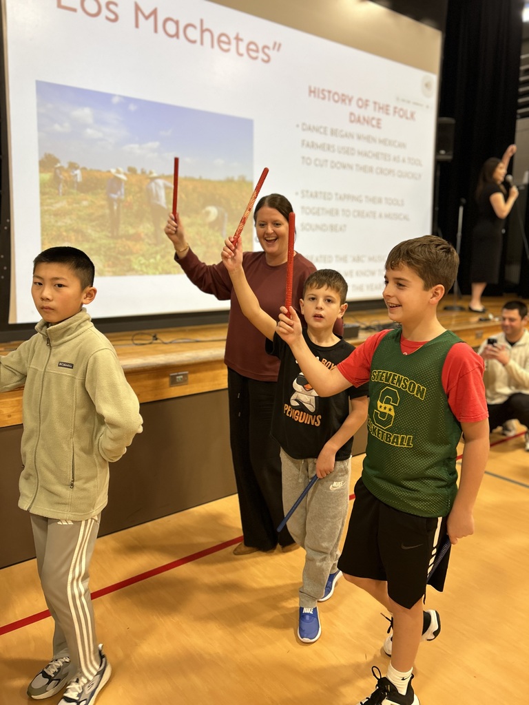 Students walking in a circle with rhythm sticks.