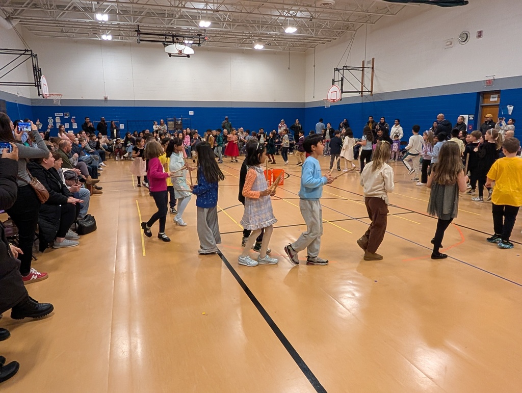 Students standing and singing in a circle.