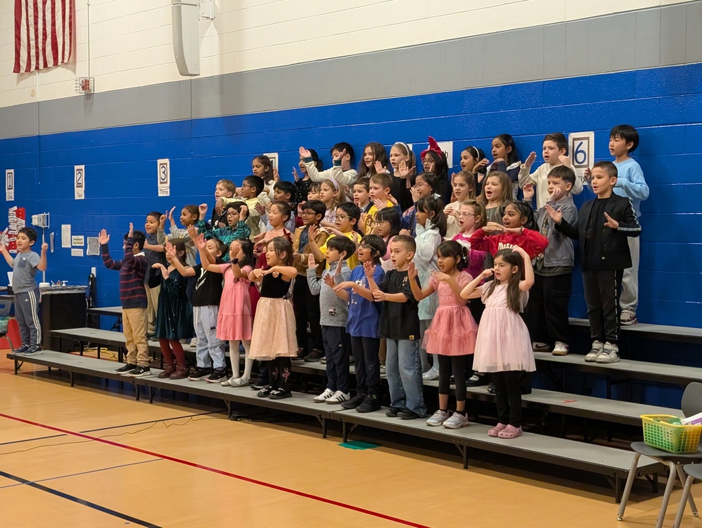 Students standing and singing on risers.