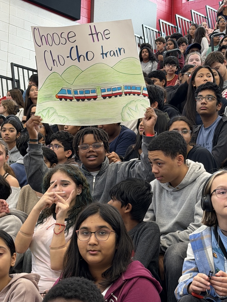 Students are cheering and holding signs in the bleachers.