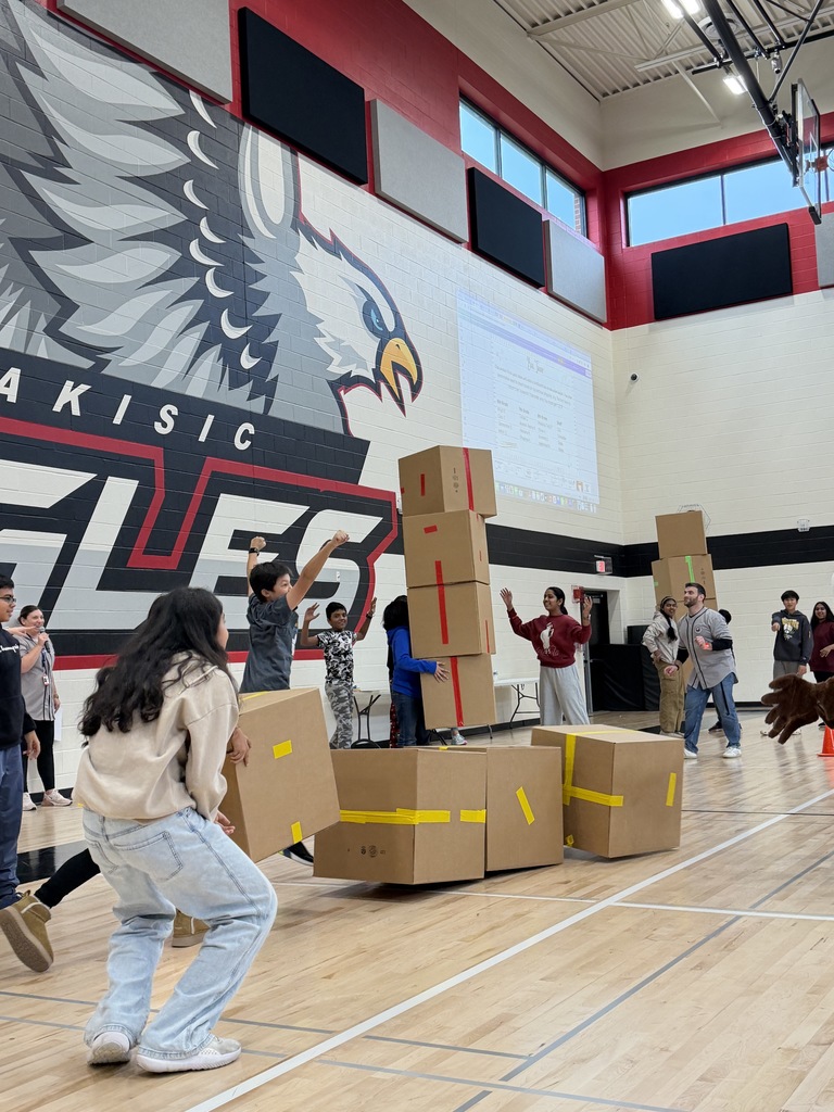 Students cheering with stacks of boxes.