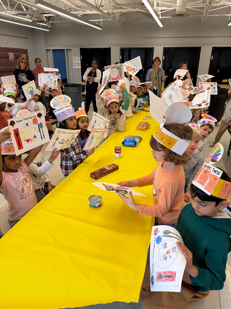 Students holding up their menus at a table.
