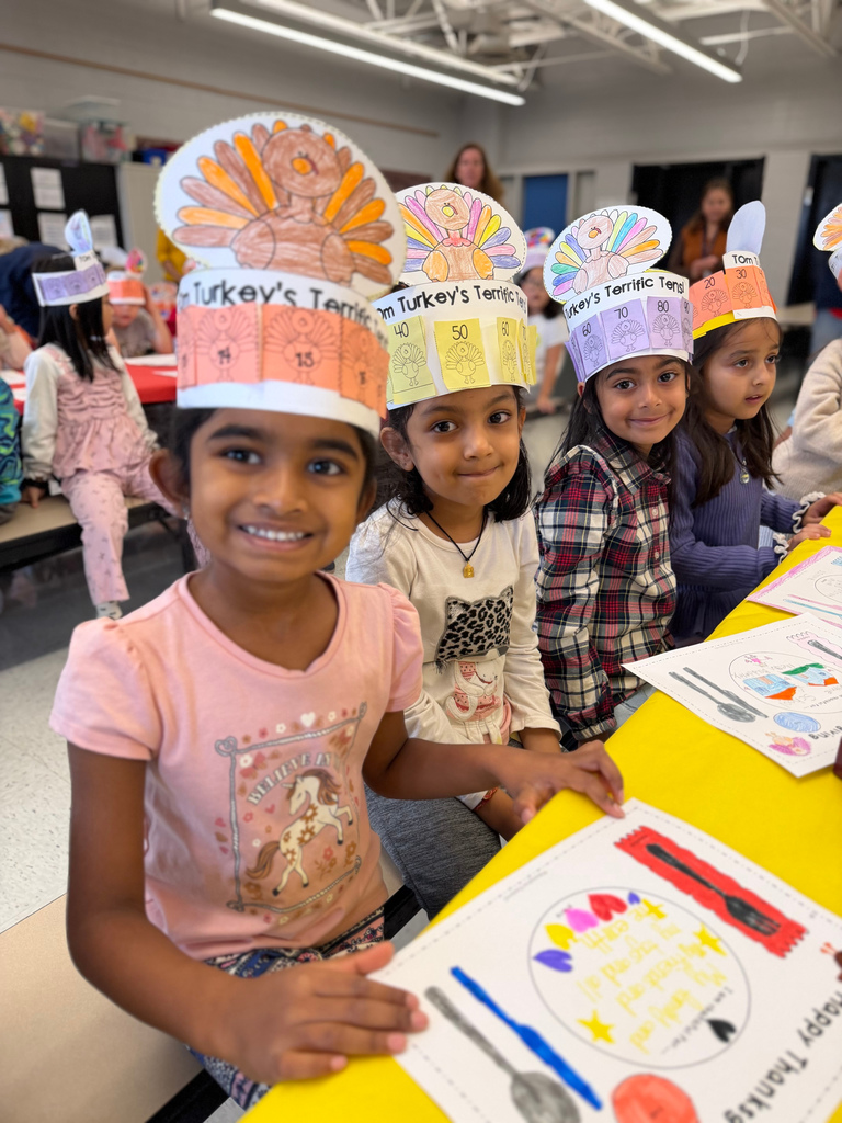 Students smiling with cute handmade hats on.