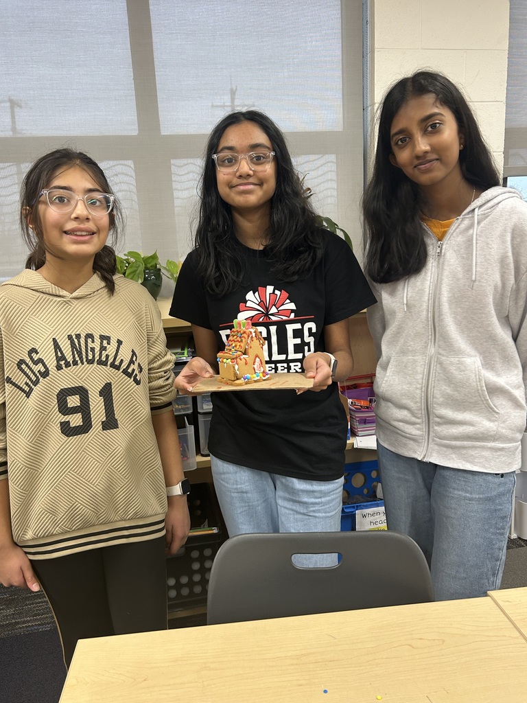 Students holding their gingerbread house.