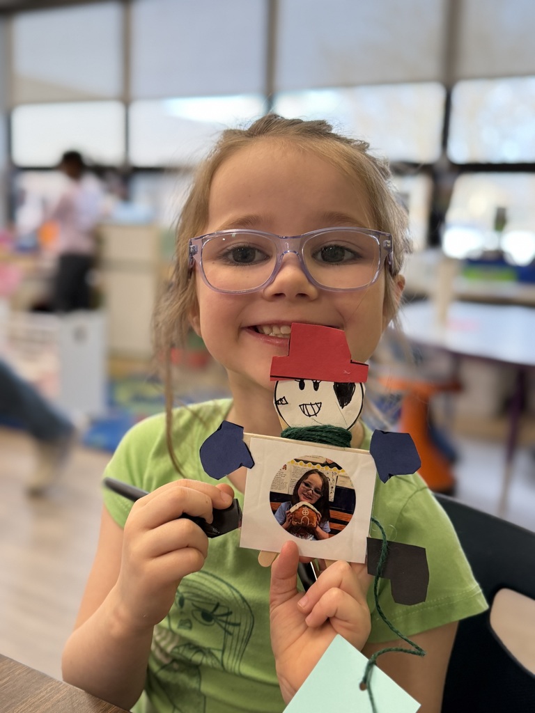 Student holding up her snowman craft.