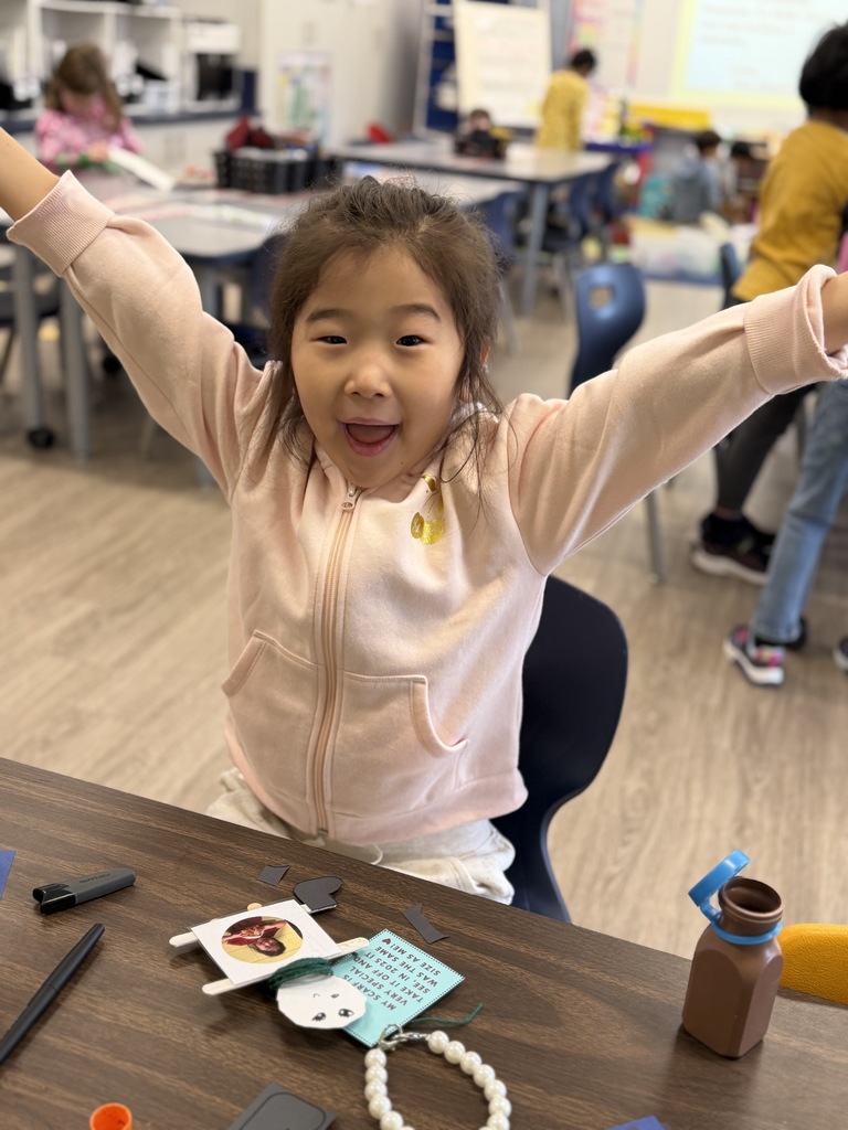 Student holding up her arms with her ornament.