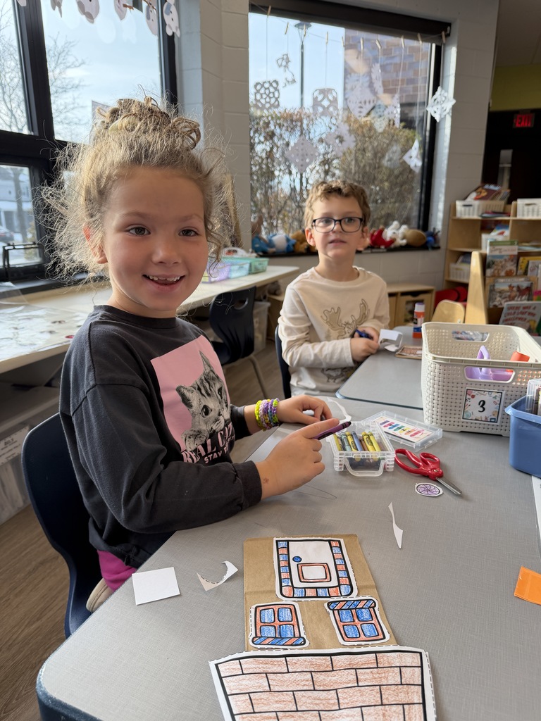 Students making gingerbread houses to use to wrap their parent gift.