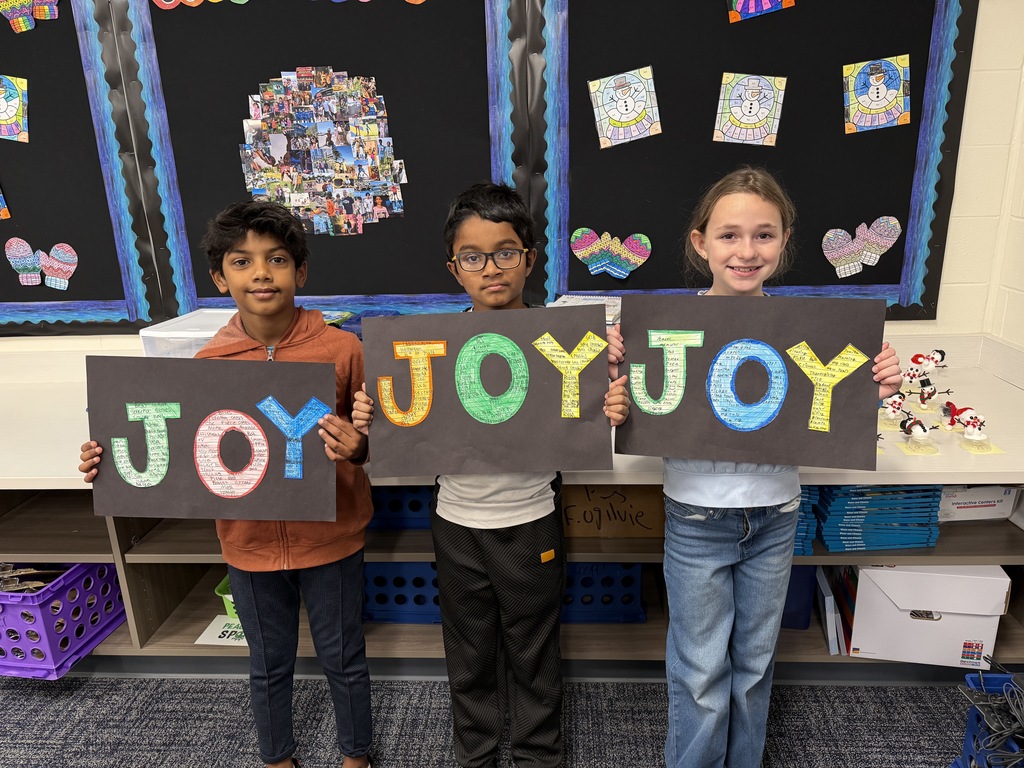 Students holding up their artwork all about joy.